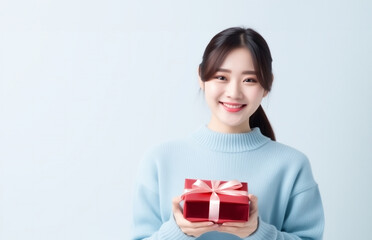 Fototapeta premium プレゼントを差し出す若い女性。日本人、上半身