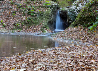 the beginning of a mountain river , a slow flow in a shallow riverbed