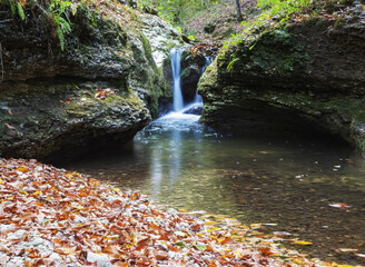 the beginning of a mountain river , a slow flow in a shallow riverbed