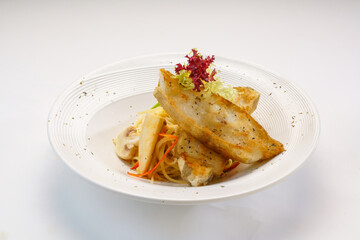 Pan fried halibut with creamy pasta and mushroom served in plate isolated on wooden table side view...