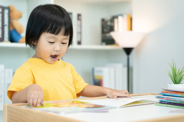Happy Asian children relax read book at home. daughter and reading a story. learn development,...