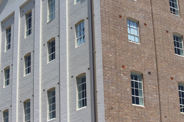 Facade of an refurbished old brick industrial building with sash windows. Now converted to apartments
