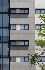 Fototapeta na wymiar Concrete exterior of an apartment building. Black window frames