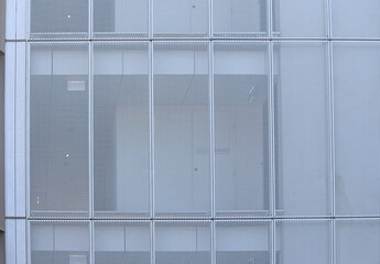 White perforated mesh screens on the exterior of an apartment building