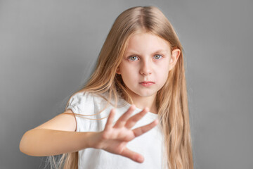 Fototapeta premium A little girl showing a sign of protest or refusal with her hand.