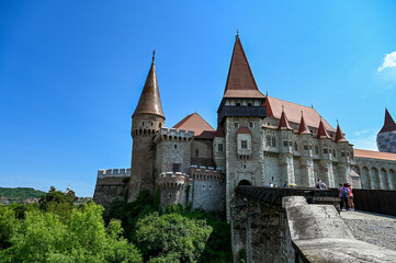 Fototapeta premium The famous Hunedoara Castle, Castelul Corvinilor or Corvin Castle with the Podul de Lemn castle bridge in summer with a blue sky, Hunedoara, Transylvania, Romania