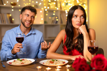 Man speaking and woman looking away, disinterested