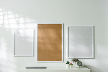 Three blank frames with copy space hanging on white wall