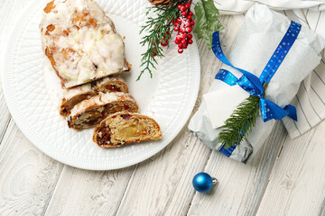 Christmas stollen on plate on white wooden table