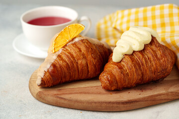 Fresh croissants with cup of tea on table