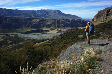 Fototapeta premium Hiking in Patagonia, Man with big backpack standing on side of hiking trail with view of valley of Rio de las Vueltas river in Los Glaciares National Park in southern Argentina