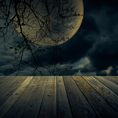 Old wooden table over dead tree, Halloween background