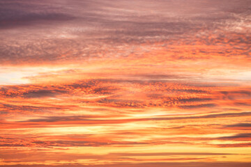 A beautiful sky tinted by the sun leaving vibrant shades of gold, pink, blue and multicolored. Clouds in the twilight evening and morning sky. Cloudy sky background in the evening and during the day.