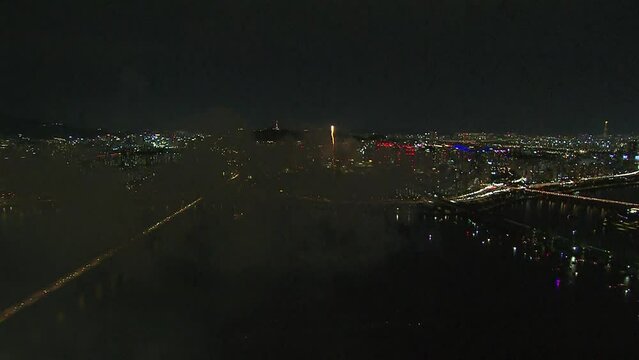한국 여의도 한강 불꽃 축제에서 수면에서 올라온 화려한 불꽃이 폭발하며 밤하늘에 빛을 발하는 부감 영상