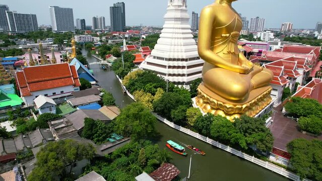 Chao Phraya River Cruise Boats Passing Big Golden Buddha Statue Wat Paknam Bhasicharoen in Phasi Charoen District in Bangkok, Thailand - aerial view