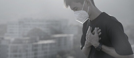 A sick young man wears a mask to protect against PM 2.5 dust coming from the city and air...
