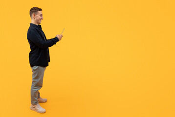 Stylish young guy using smartphone, texting friends