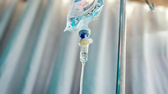 Normal saline solution (NSS) bag and infusion pump for patient in the patient room at the hospital, Saline drip in hospital room. Vitamin fluid intravenous drop saline drip hospital room.