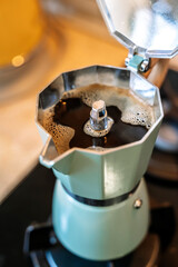 Geyser coffee maker with coffee drink on home kitchen stove in the morning