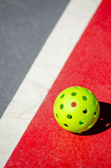 green pickleball ball isolated on a court, new racket sport