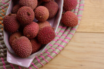 Lychee or Litchi in a pink porcelain bowl on wooden table