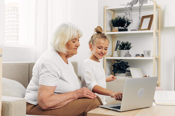 Child granddaughter grandmother togetherness education selfie laptop hugging bonding sofa smiling family