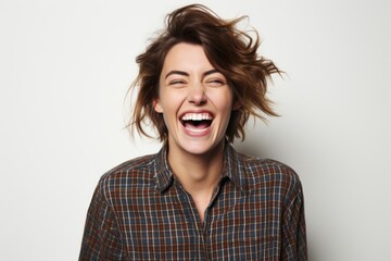 Portrait of a happy young woman laughing and looking at camera.