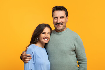Portrait of cheerful aged european wife and husband in casual looking at camera, hugs