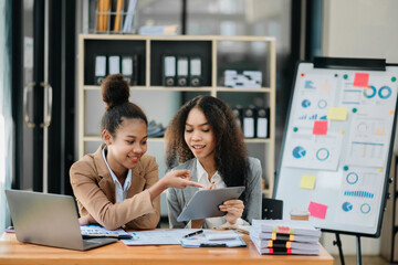 Obraz premium Two businesswoman and man discuss investment project working and planning strategy with tablet laptop computer in office.
