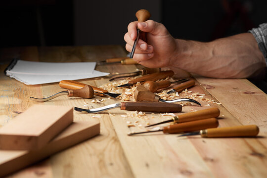 Woodworker. Timber, wood processing. Joinery work. Wood carving with work tools close up. Mans hand with a pencil in it