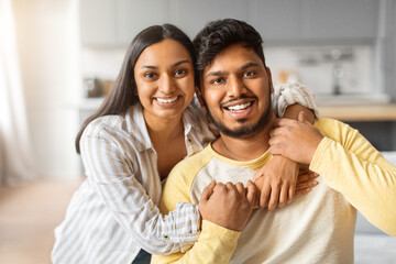 Obraz premium Portrait of joyful young indian couple embracing at home