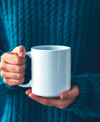 Hands holding a mug. Cozy blue sweater, concept of morning ritual with hot drink and staying home.
