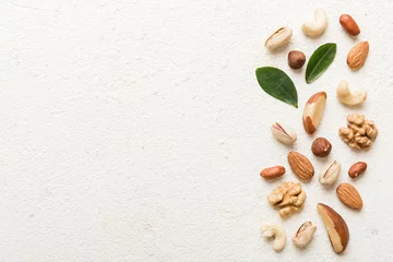 Fotobehang Composition of nuts , flat lay - mix hazelnuts, cashews, almonds on table background. healthy eating concepts and food background © sosiukin