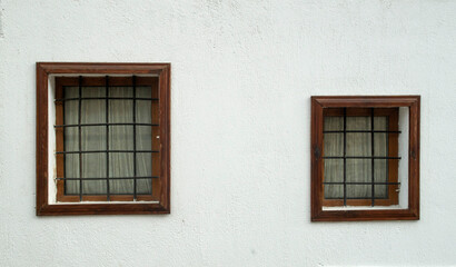 Two old wooden windows  with metal grill of different sizes