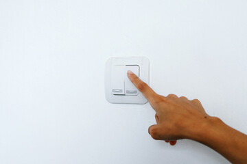 Male finger is turn off lighting switch at home. Save energy concept
