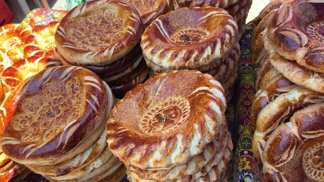 Tortillas on the market in Samarkand, Uzbekistan - June 29, 2023: Goods and traders at the Oriental Bazaar in Uzbekistan. Siab Bazaar is the largest and oldest bazaar in Samarkand. 4K