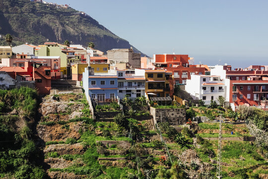 Town on a hill landscape. Tenerife island small town of Los Realejos. Houses on a cliff background. Mountain village with colorful houses. Beautiful Spanish scenery. Sunrise cityscape.	
