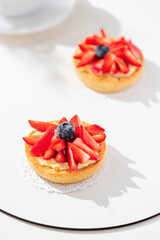 Delicious mini tart with strawberries and cream