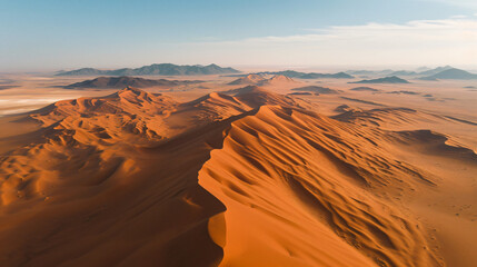 Fototapeta na wymiar Aerial view of a sprawling desert landscape at noon featuring vast sand dunes and sporadic oases.