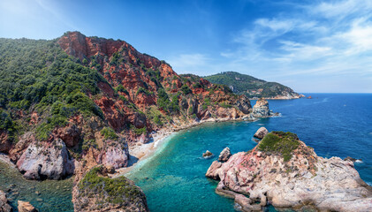 The beautiful coast of Mount Pelion,  Greece, beach near Paltsi with emerald sea and red rocks - Powered by Adobe