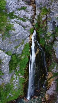 Aerial drone view of the waterfall in Theth national park, Albania. Going down the drone up and down the waterfall