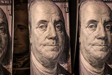 Close-up of American money rolled into rolls in backlight. 100 dollar bills. Finance and economics...