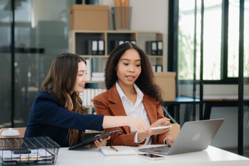 Business colleague business presents and explains and using laptop and tablet. Teamwork, financial marketing team,