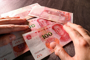 Counting money, Chinese yuan in hands. Concept of Chinese finance and economy. Selective focus. - obrazy, fototapety, plakaty