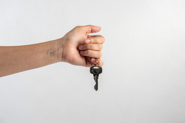 Key with a ring in hand on a white background.