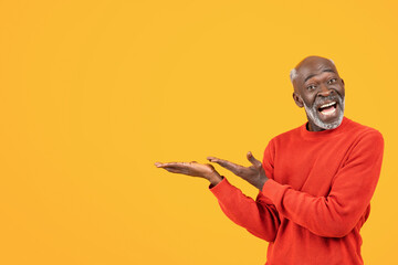 Smiling funny old african american man with beard, point hands free space