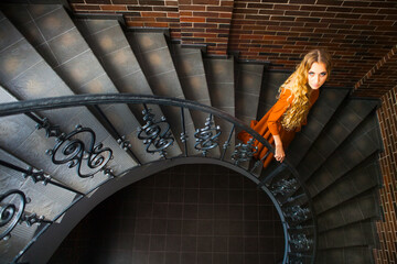 Blond woman in long dress on the stairs