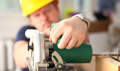 Arms of worker using electric saw closeup. Manual job workplace DIY inspiration improvement fix...