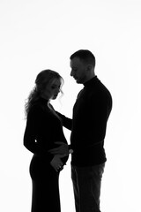 Photo of pregnant happy woman, isolated on white background, wearing black clothes. Black and white photo