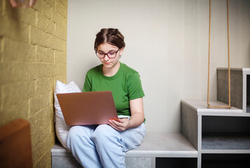 Woman browsing laptop on thq stairs